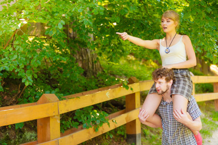 Love people and happiness concept. Travel loving couple having fun outdoor in forest. Man carrying...