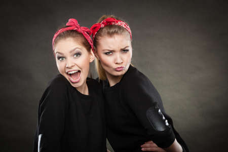 Craze fun and positive madness. Women showing their funny faces feel carefree. Girls in retro pin up fashion style present crazy behave.の写真素材