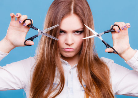 Coiffure hairstyle job work beauty concept. Professional haidresser dual wielding scissors. Young...