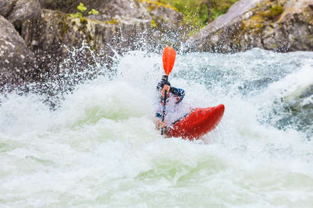 Scandinavian sports concept. People doing extreme white water mountain canoeing in rough river.の写真素材