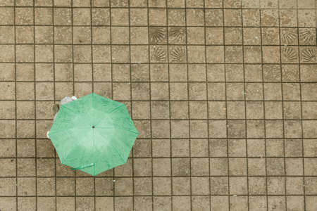 Weather nature atmosphere protection relax concept. Person with umbrella. Someone walking in rain covering himself from water.の写真素材