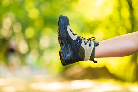 Outdoor leisure holidays trip survival trekking concept. Hiker preparing their footwear. Female tourist checking her boots before further travel.の写真素材