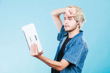 Education social media. Modern technology internet concept. Stylish handsome young man using tablet computer, thinkingの写真素材