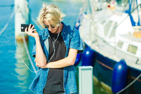 Vacation, relaxation, passion concept. Young fashionable blonde in sunglasses man relaxing,...