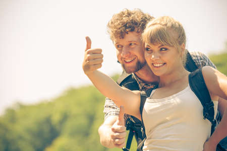 Adventure, tourism, enjoying summer time together - young couple tourists hikers having fun gesturing thumb up outdoorの写真素材