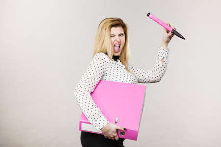 Woman holding binder with many documents and pen. Office, bookkeeping objects concept, on greyの写真素材