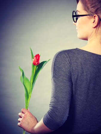 People and flowers. Girl love nature holding red green tulip spring flower. Woman adoring natural environment.の写真素材