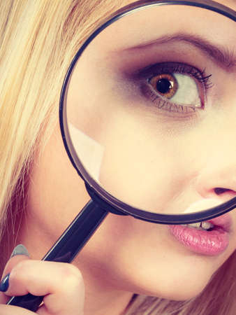 Ophthalmology, spy accessories, eyesight concept. Woman looking through magnifying glass having big one eye.の写真素材