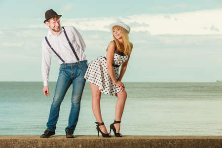 Summer holidays love relationship and dating concept - romantic playful couple retro style flirting on sea shoreの写真素材