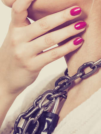 Slavery, lack of freedom speech, social problems, anxiety, sore throat, no human rights concept. Woman having heavy chain with padlock on neck.の写真素材