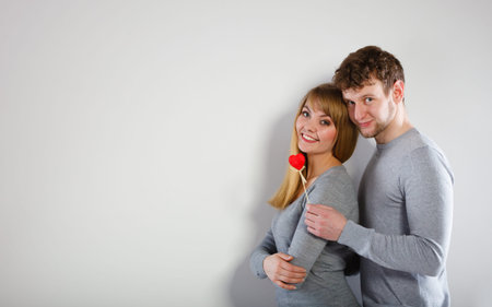 Romance feelings symbolism relationship concept. Cheering couple warming together. Young girl and boy hugging holding heart.の写真素材
