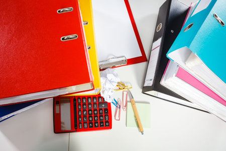Job work furniture documents concept. Office desk littered with papers. Bureau desk papers calculator.の写真素材