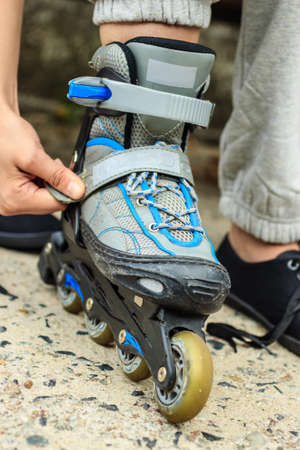 Closeup of woman girl putting on roller skates outdoor.の写真素材