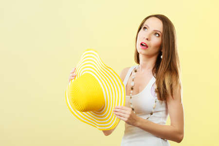 Holidays summer fashion and head protection. Woman in big yellow hat. Portrait of charming female on bright background.の写真素材