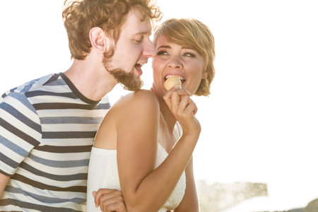 Summer holidays and happiness concept. Young couple eating ice cream outdoor city fountain in the backgroundの写真素材