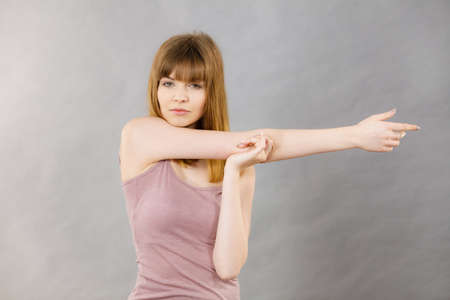 Young woman working out at home stretching her body. Training at home, being fit and healthy.の写真素材