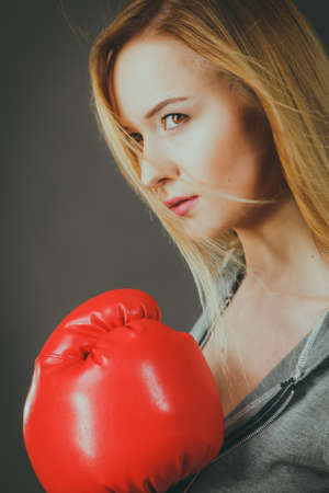 Young sensual woman, blonde attractive girl wearing red punch boxing gloves. Sport fitness and power concept.の写真素材