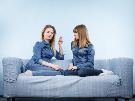 Friendship, human relations concept. Two happy women friends or sisters wearing jeans shirts having...