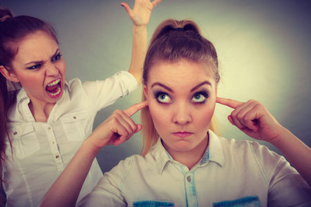 Conflict, bad relationships, friendship difficulties. Two young women having argument. Angry fury...