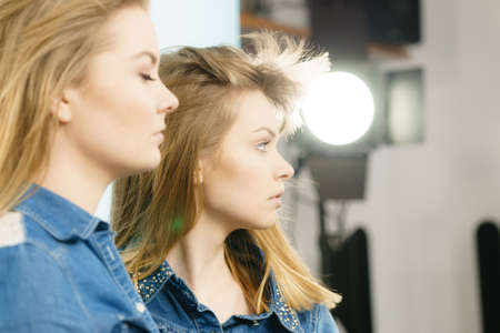 Two beautiful young blonde women having serious face expression. Feminine beauty portrait concept.の写真素材