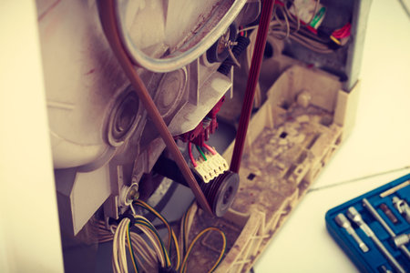 Repair mechanical industrial domestic concept. Insides of broken device. Internal parts of wasching machine exposed.の写真素材
