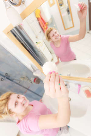 Skin complexion care concept. Young woman using cotton pad to remove make up or dirt from face.の写真素材