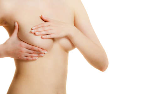 Health care medical concept. Young woman examining her breasts for lumps or signs of breast cancer isolated on whiteの写真素材