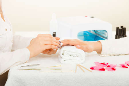 Woman hand on towel, preparing gel hybrid manicure, using nail polish remover to remove dust and oil from nails. Beauty wellness spa treatment conceptの写真素材