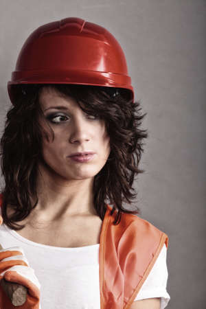 Sex equality and feminism. Sexy girl in safety helmet and orange vest. Attractive woman working as construction worker.の写真素材