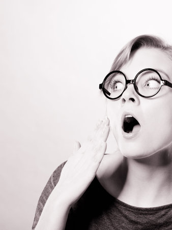 Shock and disbelief concept. Surprised astonished girl with wide open mouth. Amazed female looking very shocked. Facial expression and body language.の写真素材