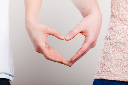 Symbols of love. Couple showing their connection and feelings by holding their hands strongly in...