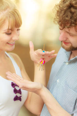 Real estate and family concept. Couple showing their new house keysの写真素材