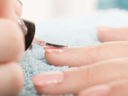 Closeup of beautician painting nails of female client. Woman in beauty spa salon doing manicureのeditorial素材