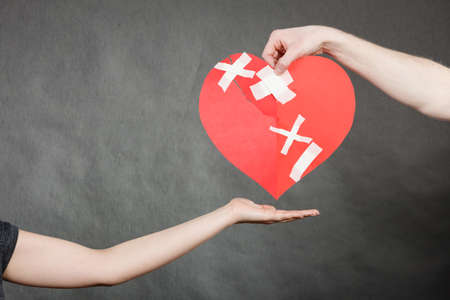 Bad relationships, breaking up, sadness emotions concept. Man hand giving someone broken heart.の写真素材