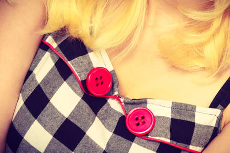 Tailoring, patterns concept. Woman wearing retro checked black and white dress with two red buttons.の写真素材