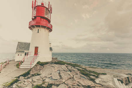 Historic red white lighthouse on the edge of rocky sea coast, South Norway, Lindesnes Fyr beaconのeditorial素材