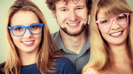 Happy playful young women in glasses. Smiling hipster friends girls and man having fun.の写真素材