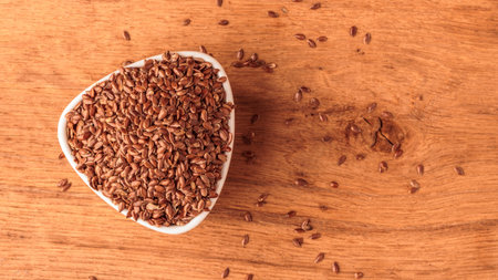 Healthy food diet. Brown flax seeds linseed in white bowl on wooden tableの写真素材