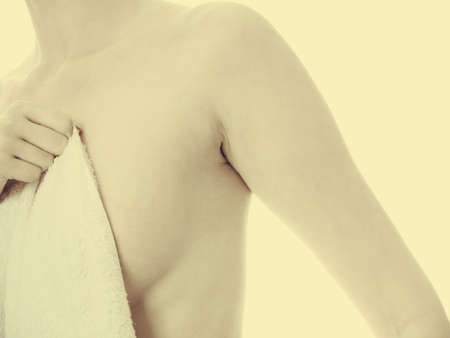 Shame and fear. Part body woman shamed of her nudity covering her breast with big bath towel. Innocence of female.の写真素材