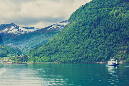 Tourism vacation and travel. Mountains landscape and ferryboat sailing on fjord in Norway Scandinavia Europe. Norddalsfjorden as seen from ferry. Beautiful natureの写真素材
