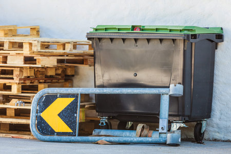 Outdoor shot of heavy dark industrial trash waste dumpster container in factory.