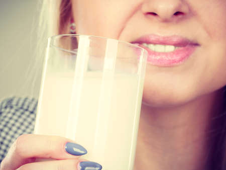 Healthy drinks, good nutrition, perfect breakfast concept. Woman drinking milk from glassの写真素材