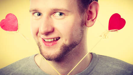 Romance feelings affection gift valentines concept. Cheerful man holding hearts. Young male waving love symbols.の写真素材