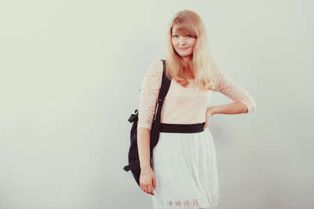 Pretty young woman girl student with backpack bag. Gorgeous teenager in studioの写真素材