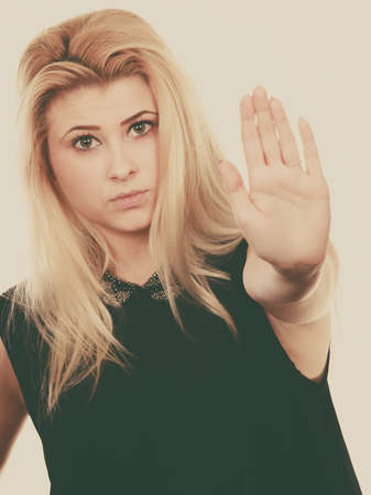 Denial, rejection gestures concept. Blonde woman making stop gesture with open handの写真素材