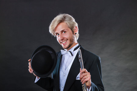 Classical music, passion, hobby concept. Elegantly dressed musician man holding flute and black...