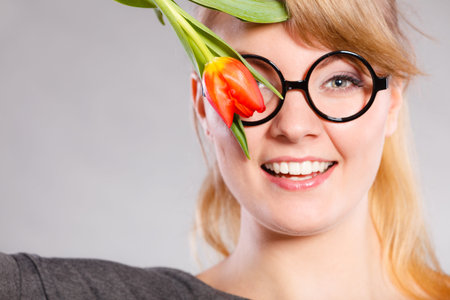 Fun casual flora nature beauty feminine concept. Cheerful girl with flower. Smiling lady in glasses...