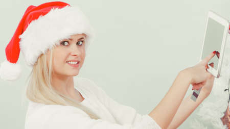 Christmas time concept. Young woman teen girl with tablet pc laptop and credit card on sofa at home doing online shopping, buying browsing for gifts, having funの写真素材