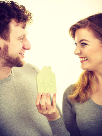 Property ownership family future finances mortgage bank concept. Youthful pair with house model. Young lady with man posing together with home symbol.の写真素材