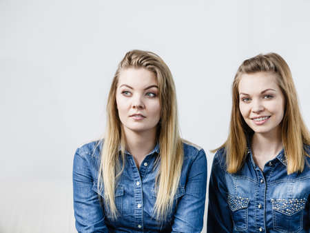 Friendship, human relations concept. Two happy women friends or sisters wearing jeans shirts.の写真素材